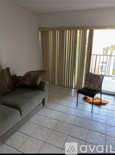 A living room with a grey couch and a chair.