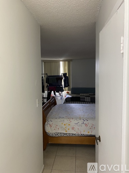 A bedroom with a bed, a desk, and a chair.