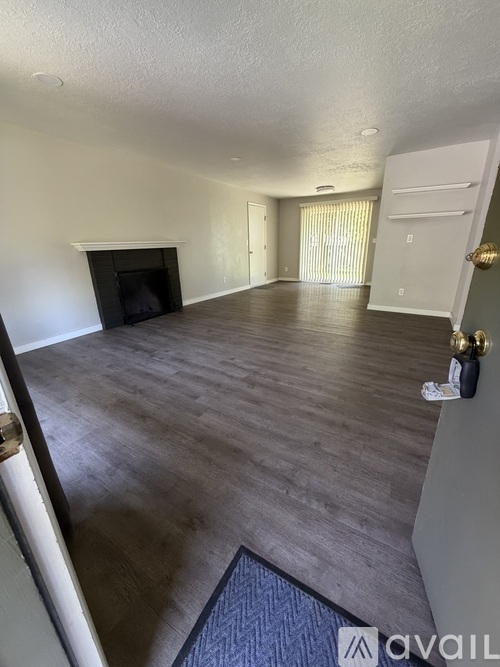 A spacious living room with a fireplace and hardwood floors.
