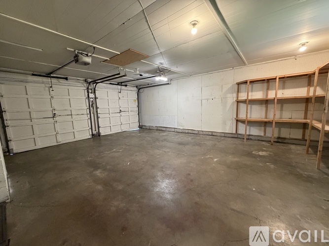 A spacious garage with a concrete floor and a white wall.
