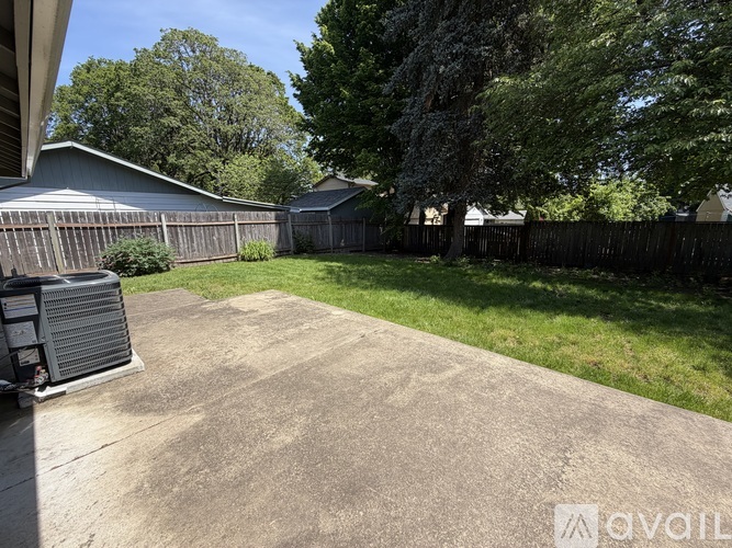 A backyard with a concrete patio and a pool heater.