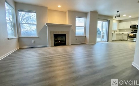 A spacious living room with a fireplace and hardwood floors.