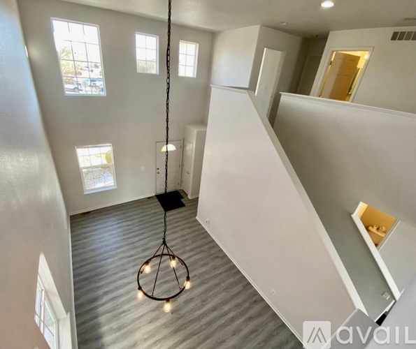 A modern interior with a wooden floor and a hanging light fixture.