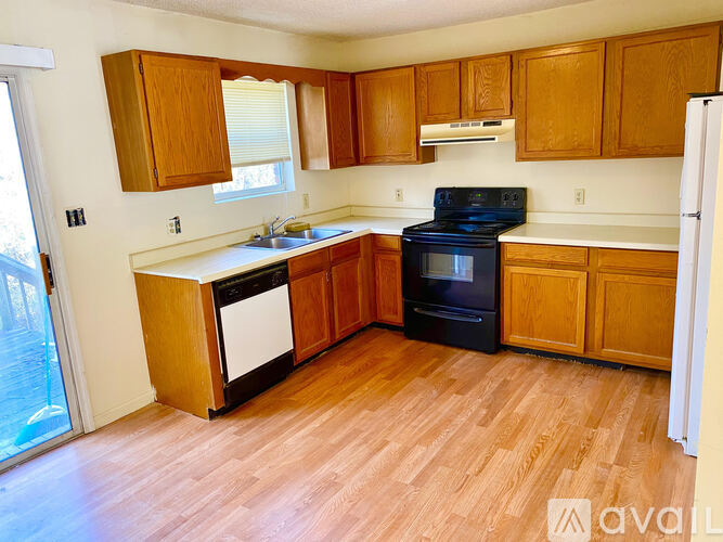 A kitchen with wooden cabinets and a black stove top oven.
