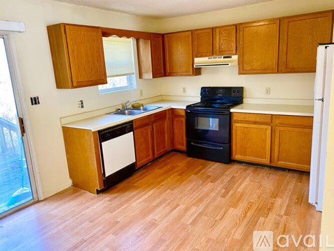 A kitchen with wooden cabinets and a black stove top oven.