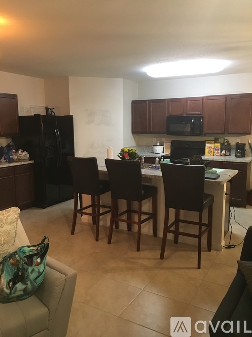 A kitchen with a table and chairs in the middle.