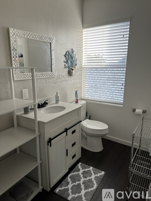 A bathroom with a white sink and toilet.