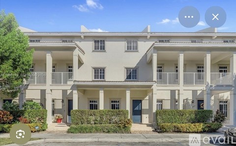 A large white building with multiple balconies and doors.