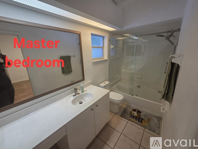 A bathroom with a sink, mirror, and shower.