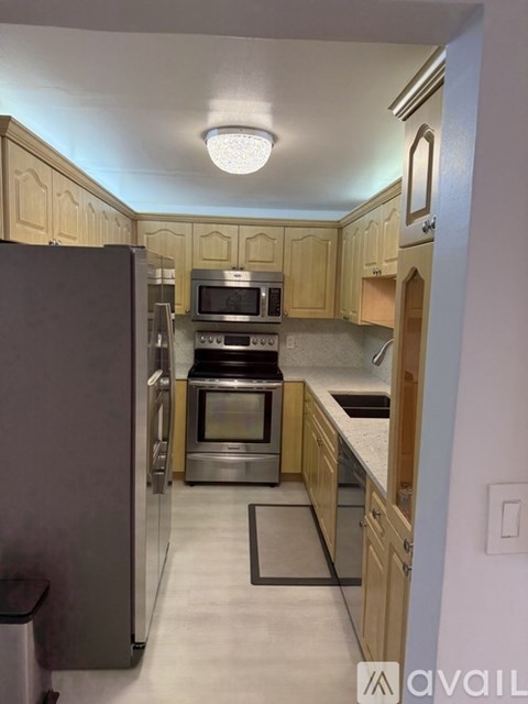 A kitchen with wooden cabinets and stainless steel appliances.