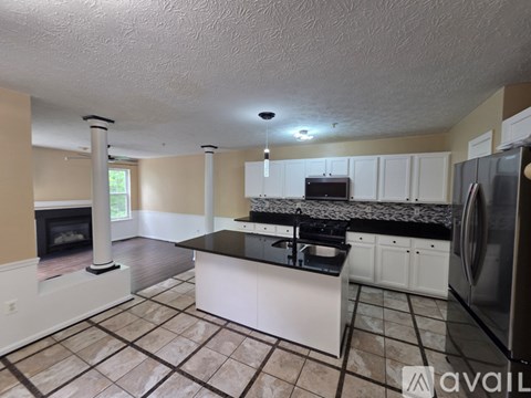 A kitchen with white cabinets and a black countertop.