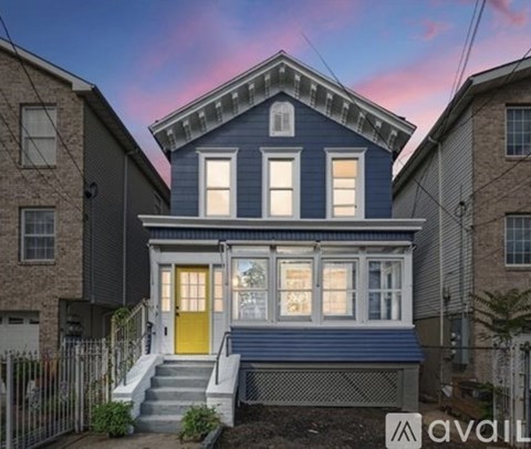A blue house with a yellow door stands out against its neighbors.