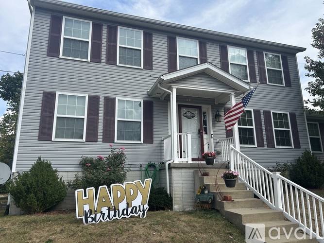 A house with a "Happy Birthday" sign in front of it.