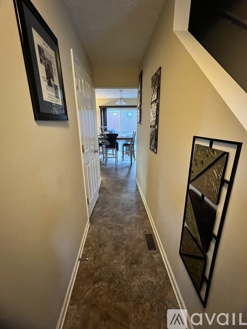 A hallway with a table and chairs in the background.