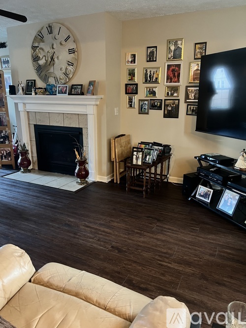 A living room with a fireplace, a couch, and a TV.
