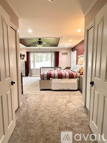 A bedroom with a bed and a ceiling fan.