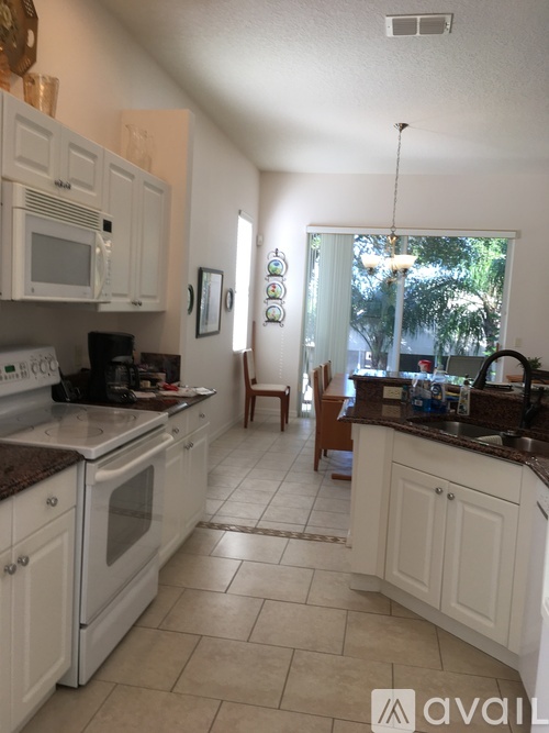 A kitchen with white cabinets and a brown countertop.