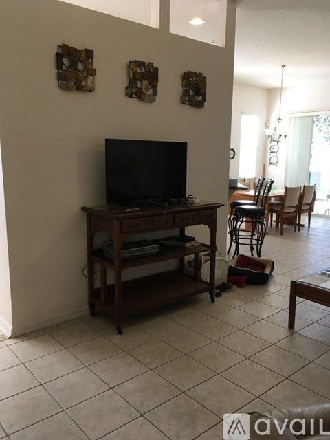 A living room with a television and a wooden stand.