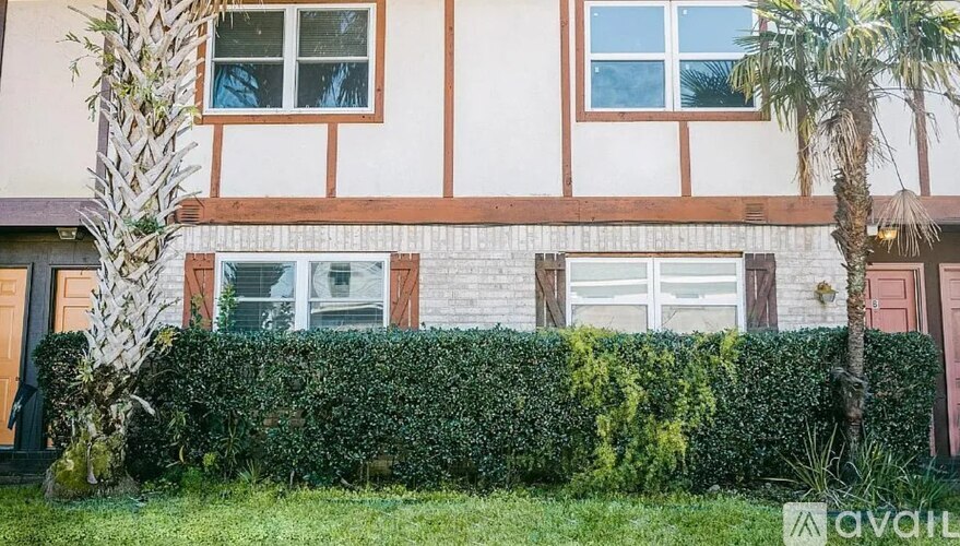 A house with a hedge in front of it.