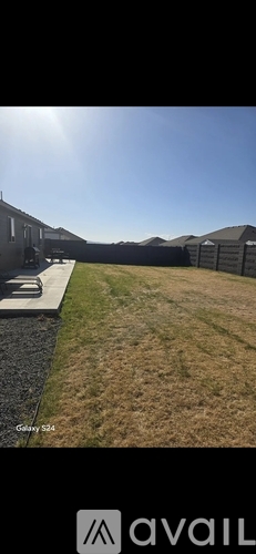 A sunny day in a residential area with houses and a grassy area.