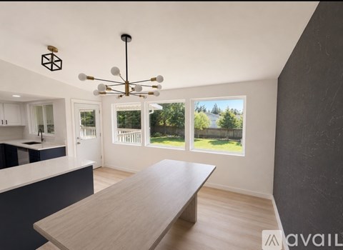 A modern kitchen with a long wooden table and a chandelier.