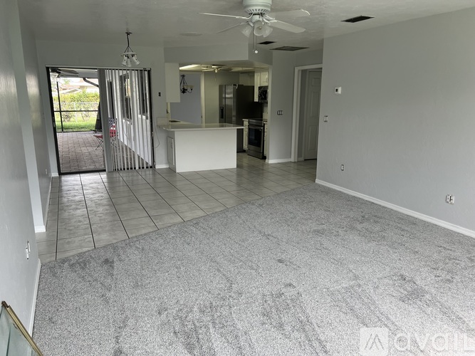 A spacious room with a ceiling fan and sliding glass doors.