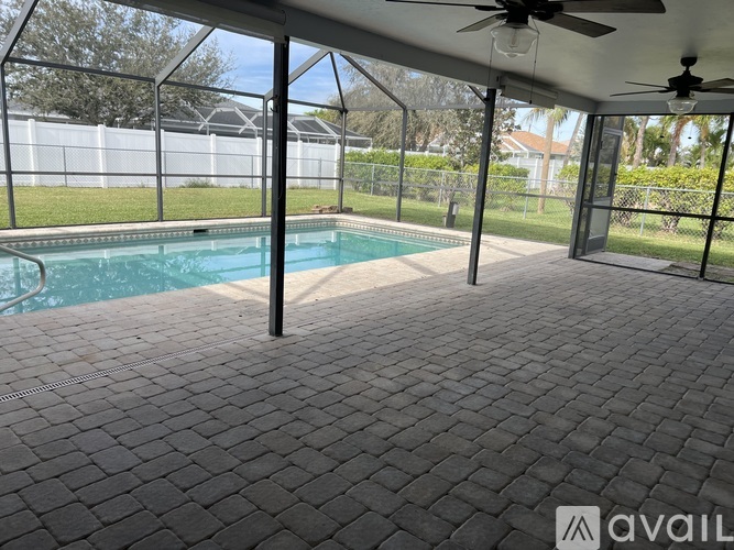 A patio with a pool and a ceiling fan.