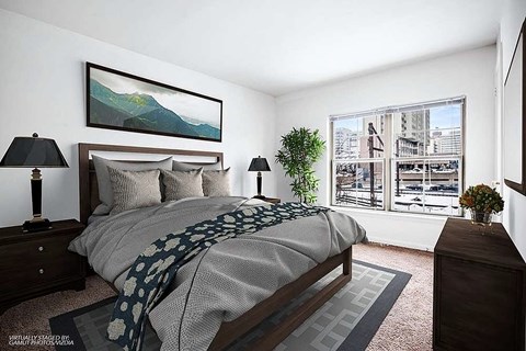 A bedroom with a large bed and a painting on the wall.