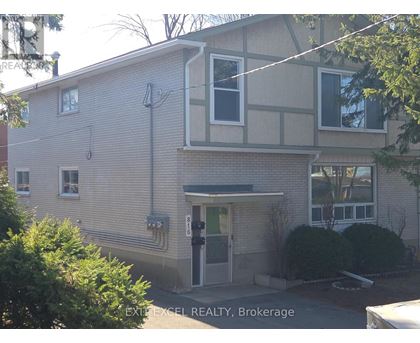 A building with a sign that says EXIT EXCEL REALTY, Brokerage.