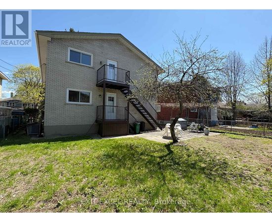 A house with a balcony and a tree in front of it.