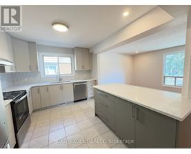 A kitchen with white countertops and grey cabinets.