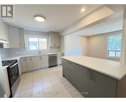 A kitchen with white countertops and grey cabinets.