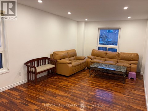 A living room with a brown sofa and a wooden chair.