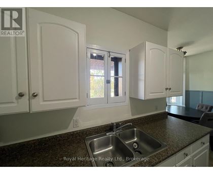 A kitchen with white cabinets and a granite countertop.