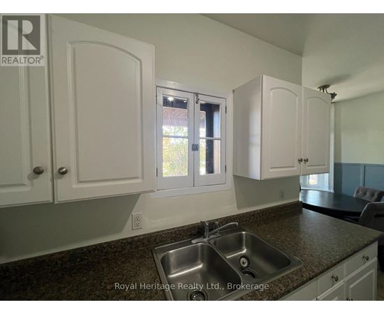 A kitchen with white cabinets and a granite countertop.
