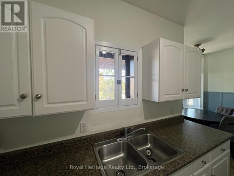 A kitchen with white cabinets and a granite countertop.