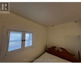 A bedroom with a bed, window, and a wooden headboard.