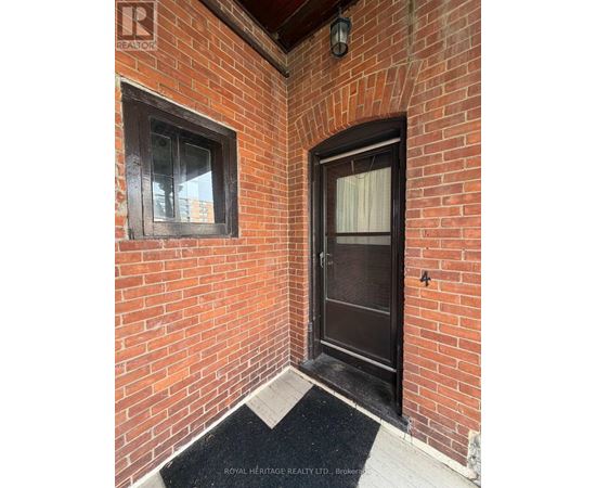 A door with a window on the left and a black mat in front of it.