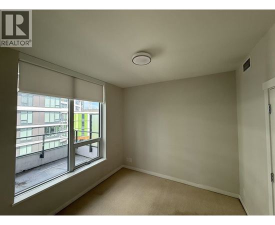 A room with a window overlooking a balcony.