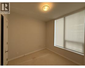 A room with a window and a carpeted floor.