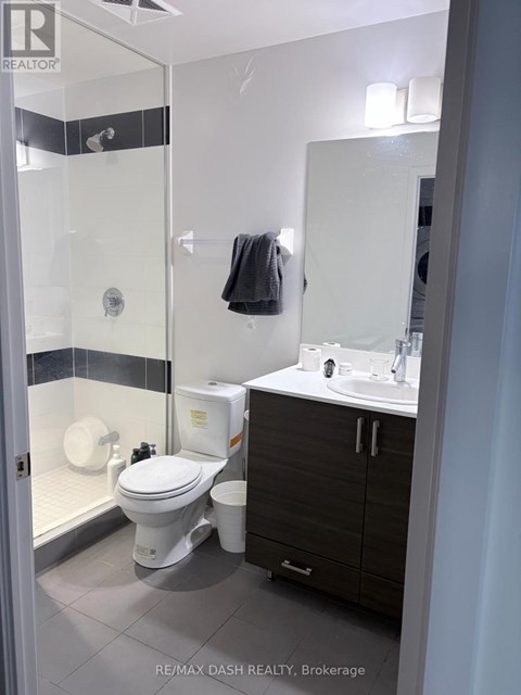 A bathroom with a toilet, sink, and mirror.
