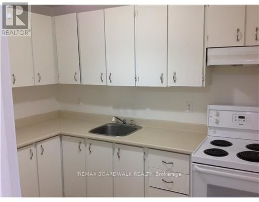 A kitchen with white cabinets and a white stove top oven.
