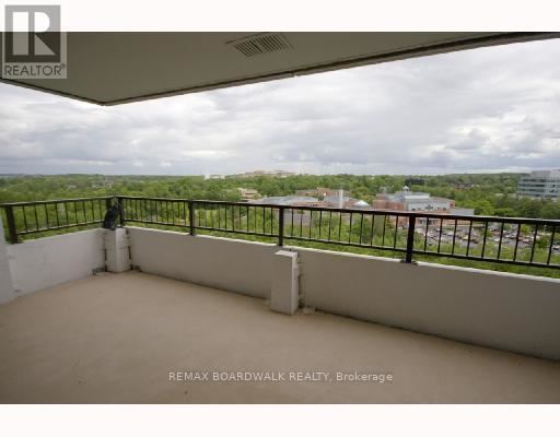 A balcony with a black railing and a person standing on it.