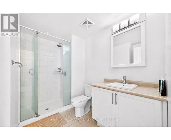 A white bathroom with a glass shower stall and a toilet.