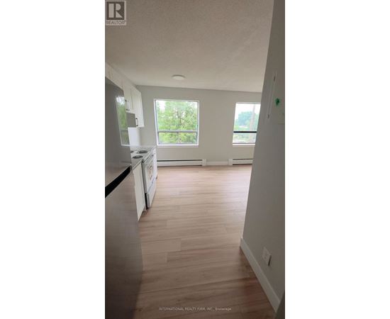 A kitchen with white cabinets and a wooden floor.
