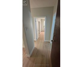 A hallway with wood floors and white walls.