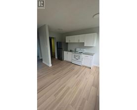 A kitchen with white cabinets and a white stove top oven.
