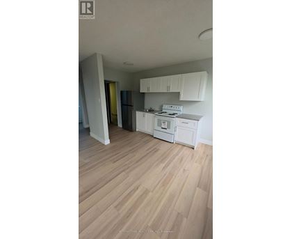 A kitchen with white cabinets and a white stove top oven.