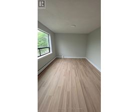 A room with wooden flooring and a window.