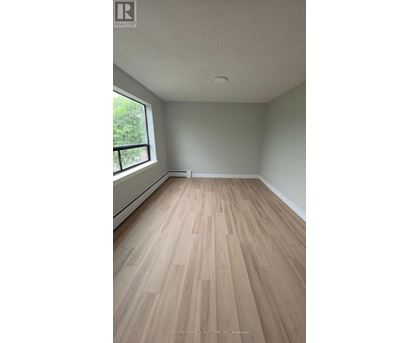 A room with wooden flooring and a window.